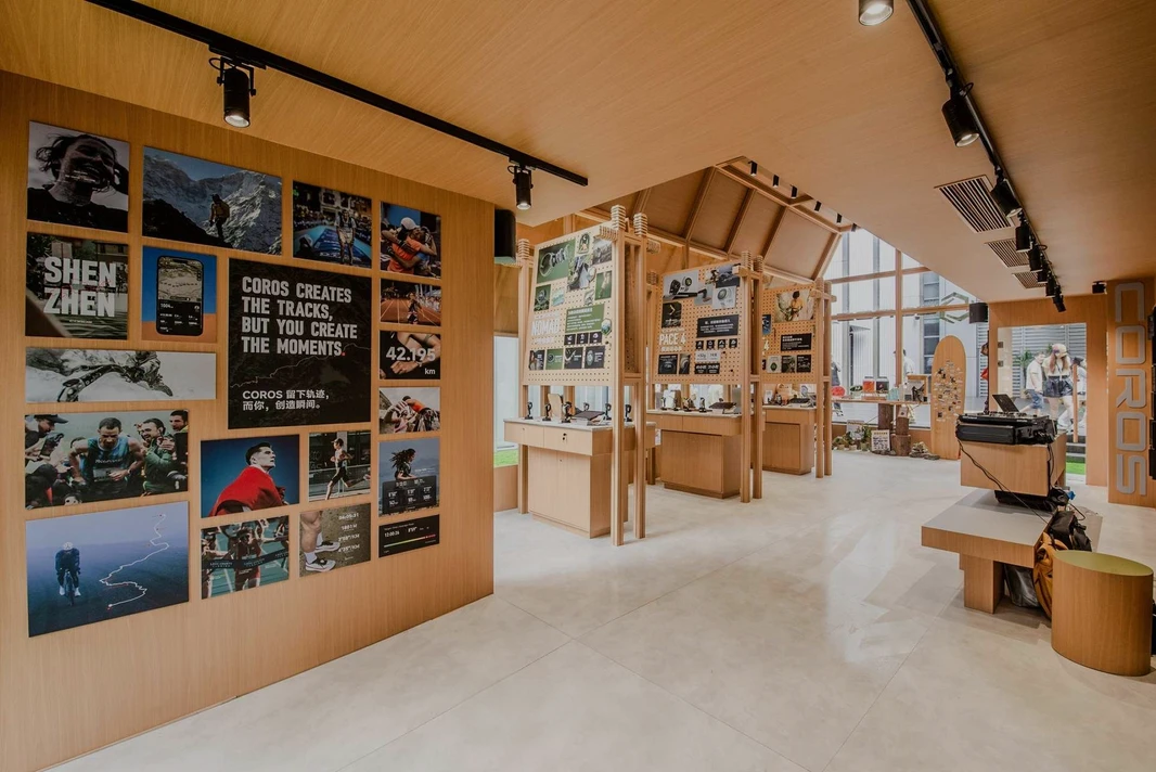 Showroom COROS con orologi sportivi, espositori di prodotti e fotografie di atleti.
