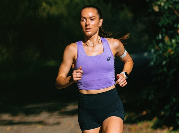 Australian marathoner Izzi Batt-Doyle running on a paved path through a park.