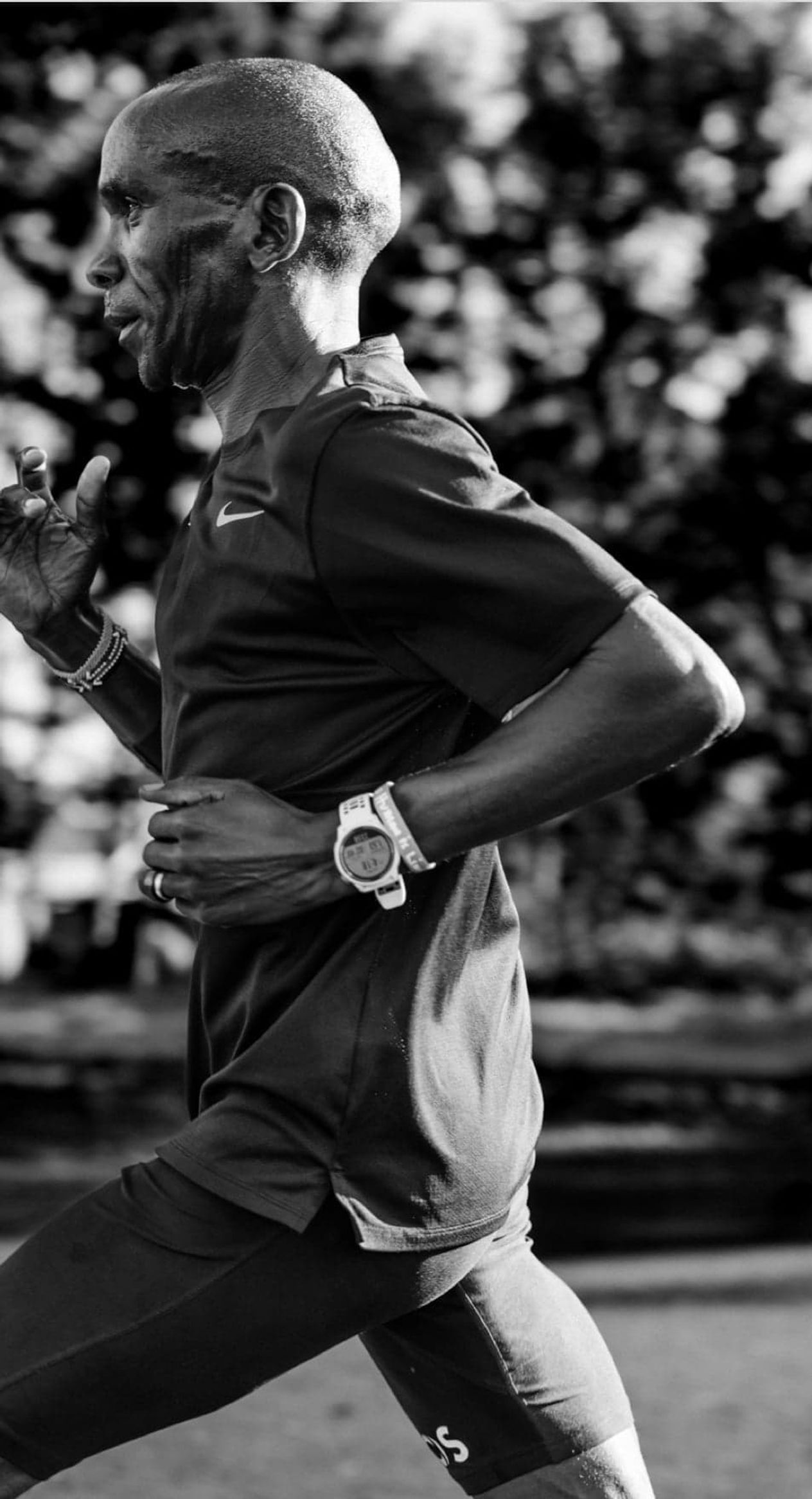 A close-up image of Eliud Kipchoge running with a COROS PACE 2 White Watch with a silicone band.