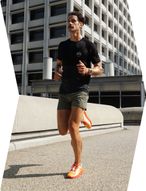 A runner in motion on the street wearing the COROS POD 2 on his foot.
