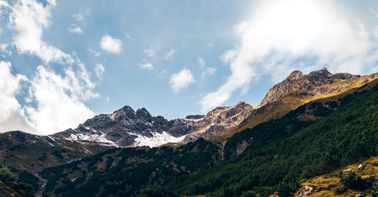 A scenic view of mountains and sky with great sunlight.