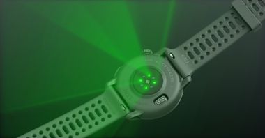 An image of the optical heart rate sensor emitting green lights from a black COROS PACE 3 watch with black silicone band.
